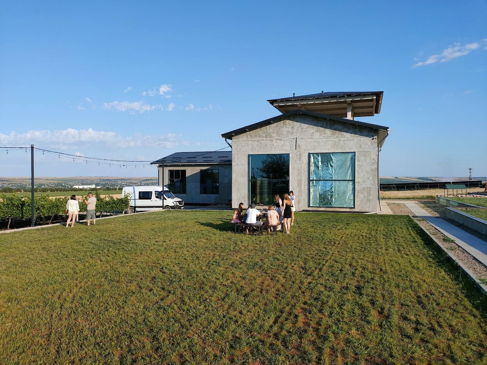 Modern winery building with vineyard rows and outdoor terrace in Moldova