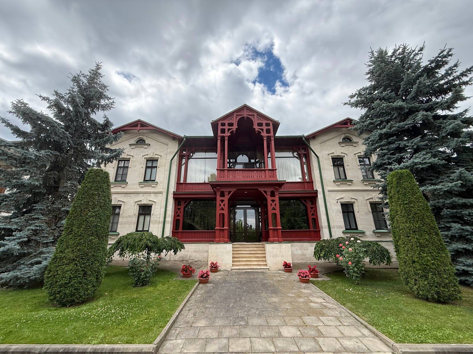 Historic mansion with dual wings and red central entrance pavilion
