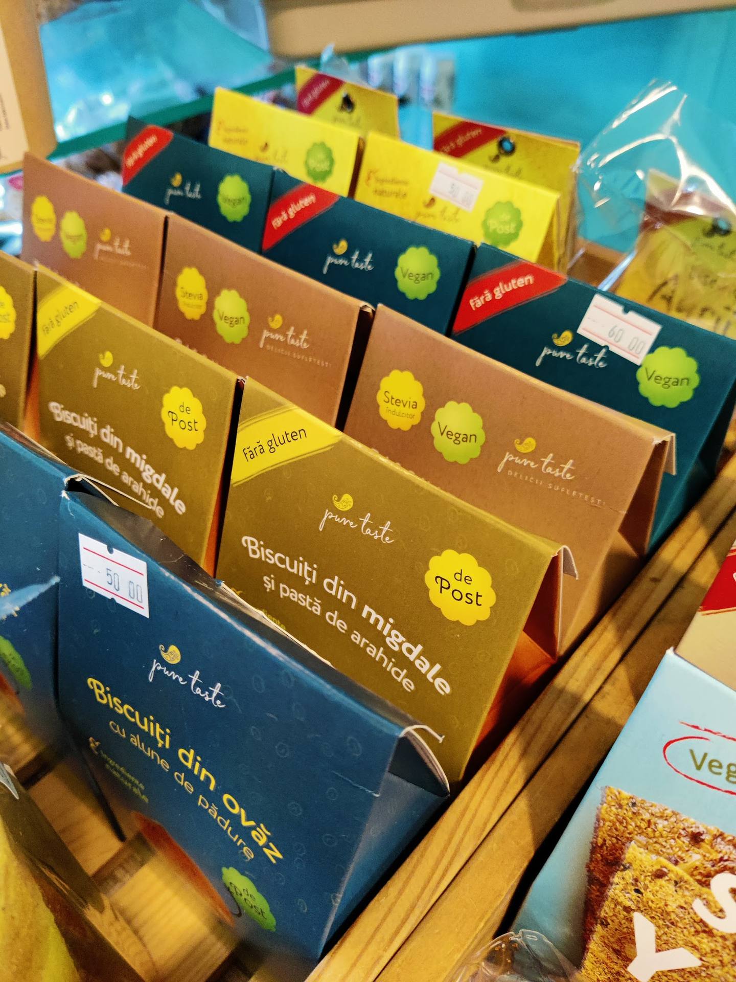 Colorful packaged biscuits and pastries displayed on wooden shelf