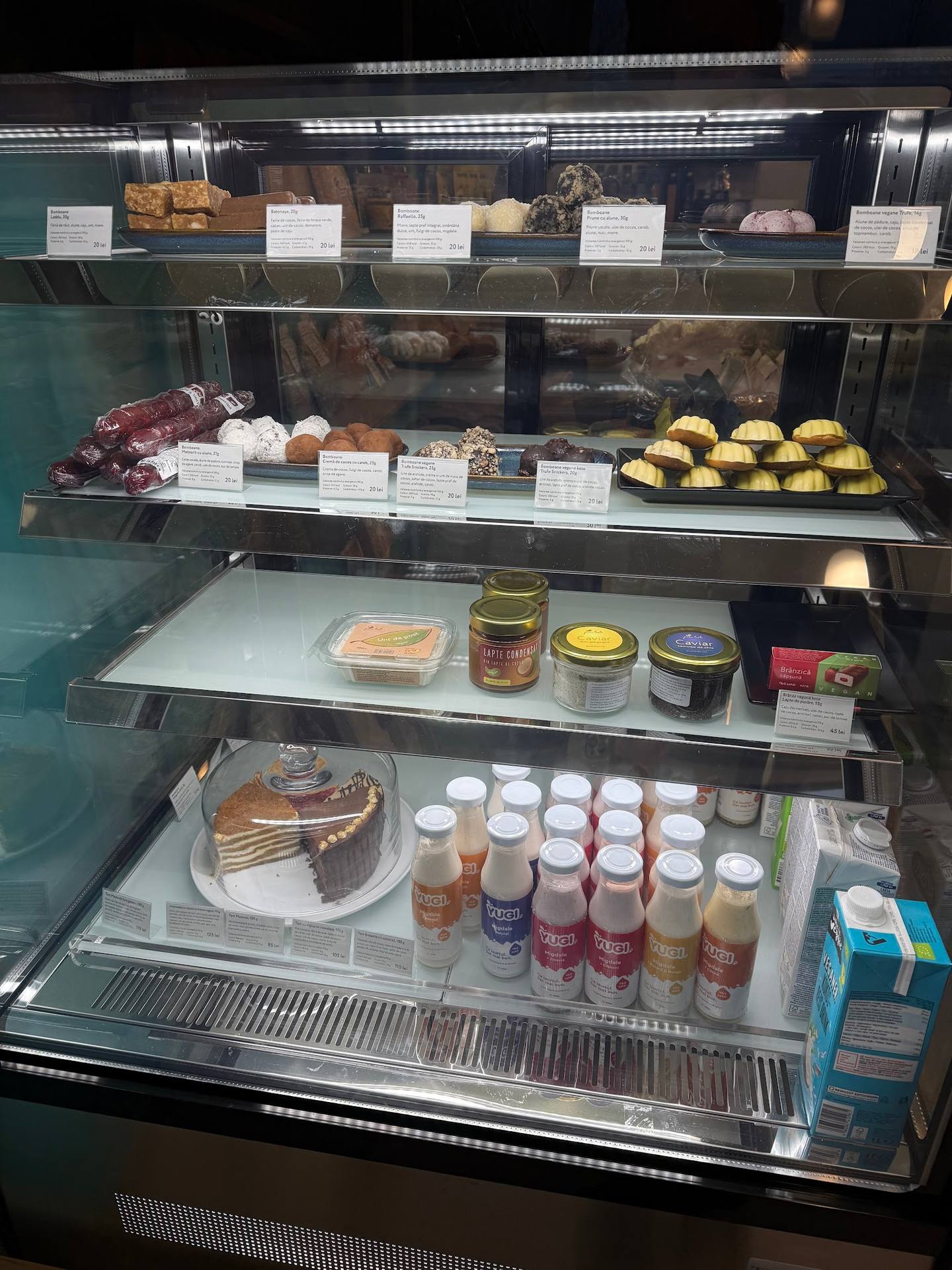 Bakery display case with pastries, cakes, jams, and prepared foods