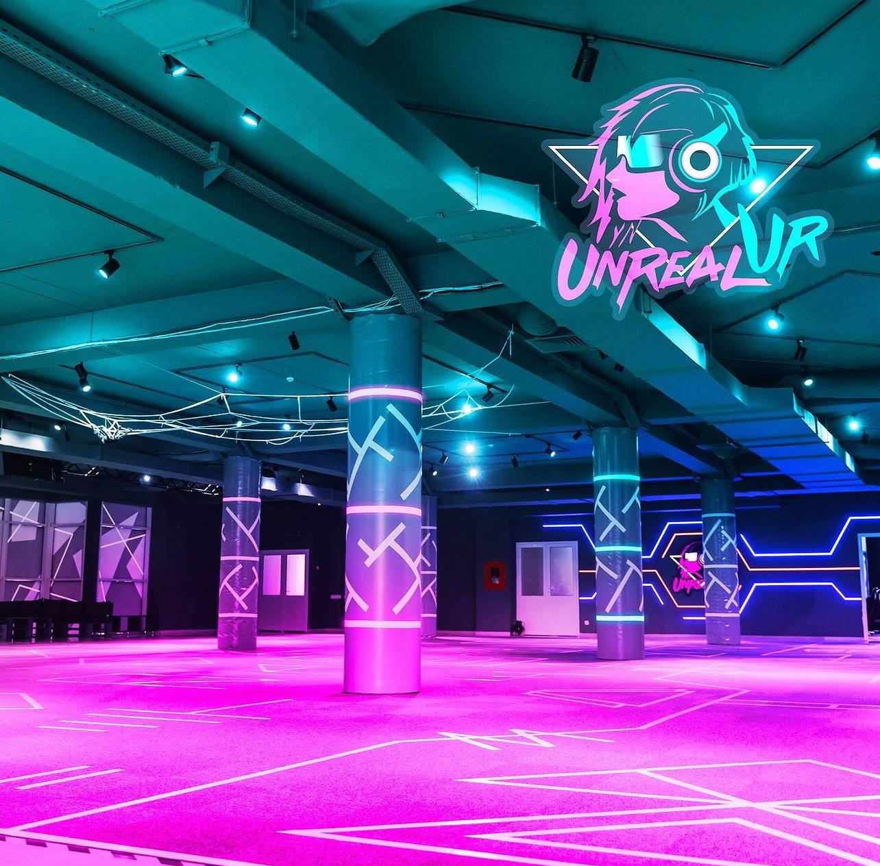 Neon-lit gaming arena with magenta dance floor and digital branding