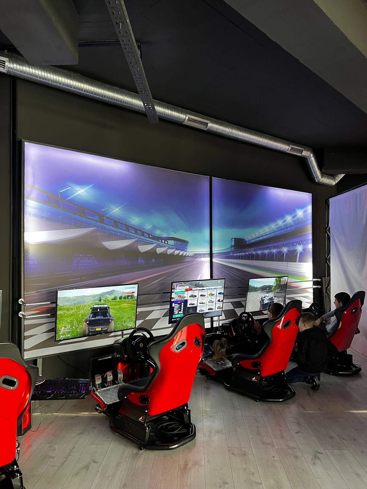 Racing simulator station with professional motion seats and panoramic display screens
