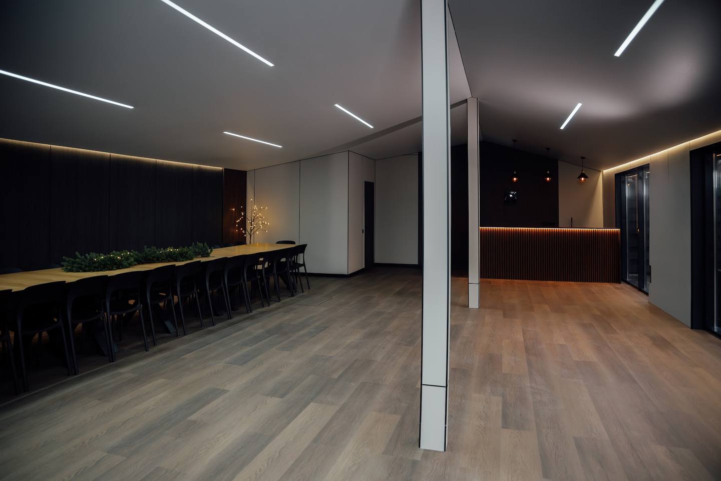 Modern event space with bar counter, wooden floors, and ambient lighting
