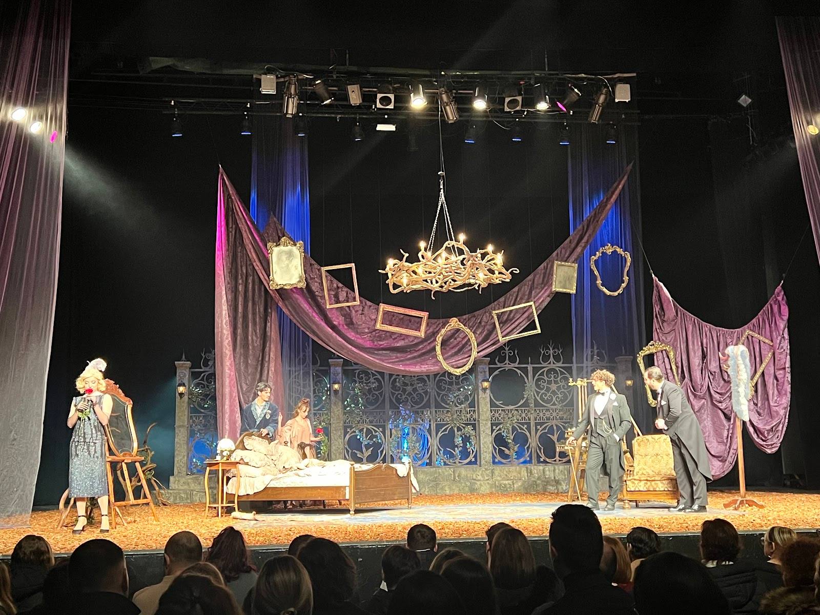 Theatrical stage with ornate chandelier and pink draped décor for an elegant event