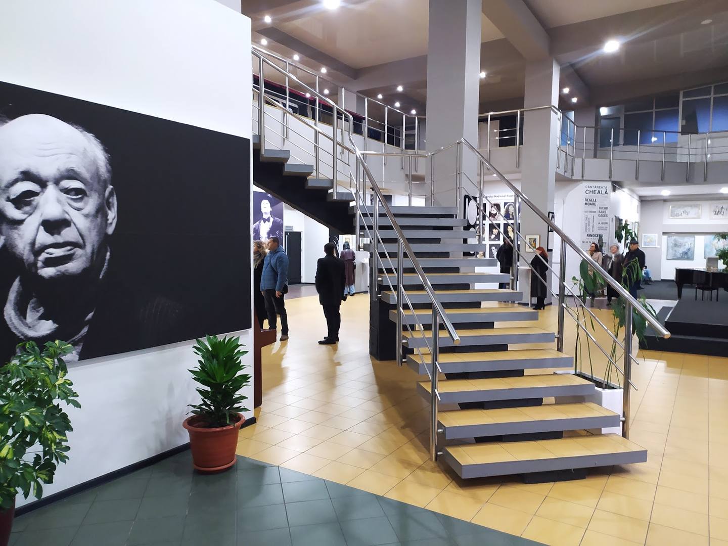 Modern interior atrium with central staircase, portrait display, and mezzanine levels