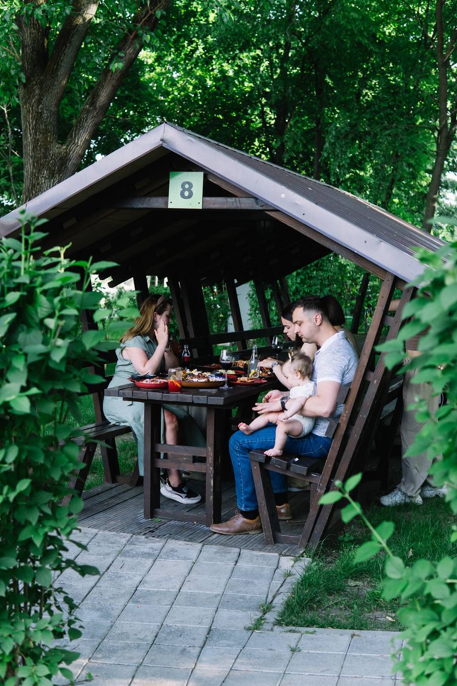 Outdoor game pavilion nestled in lush greenery with table games setup
