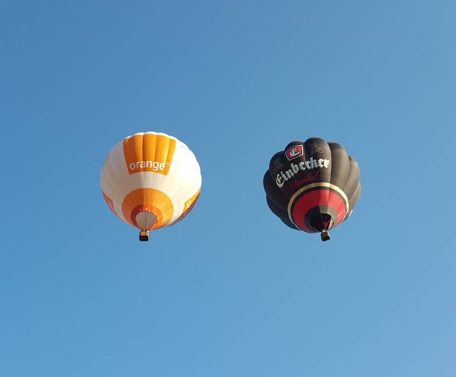 Hot air balloons in flight against clear blue sky