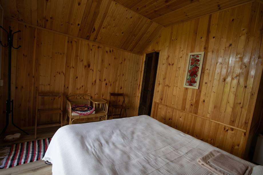 Rustic wooden bedroom interior with traditional wood paneling and simple furnishings