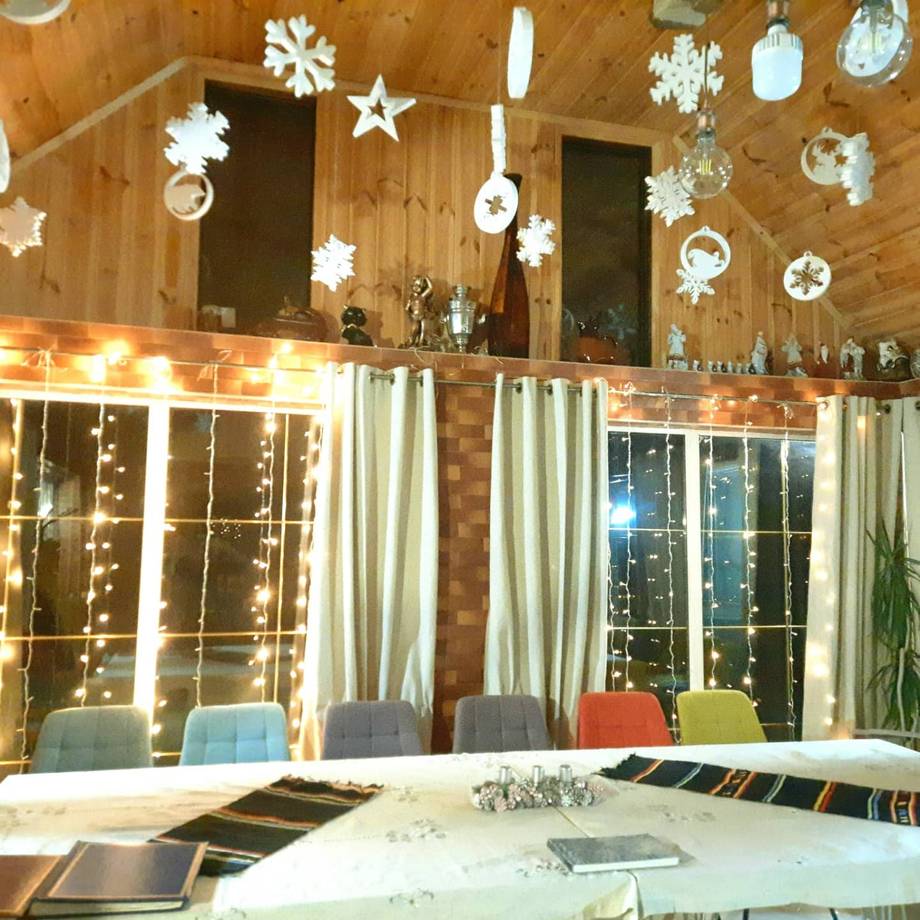 Warm wooden interior with festive white holiday decorations and long dining table