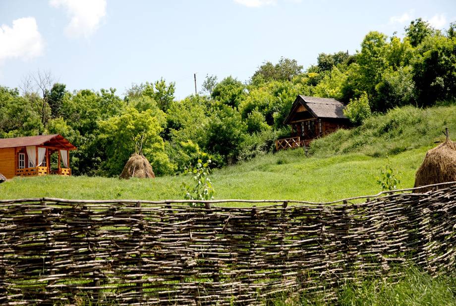 Rural homestead with traditional fence and period buildings nestled in green hillside landscape