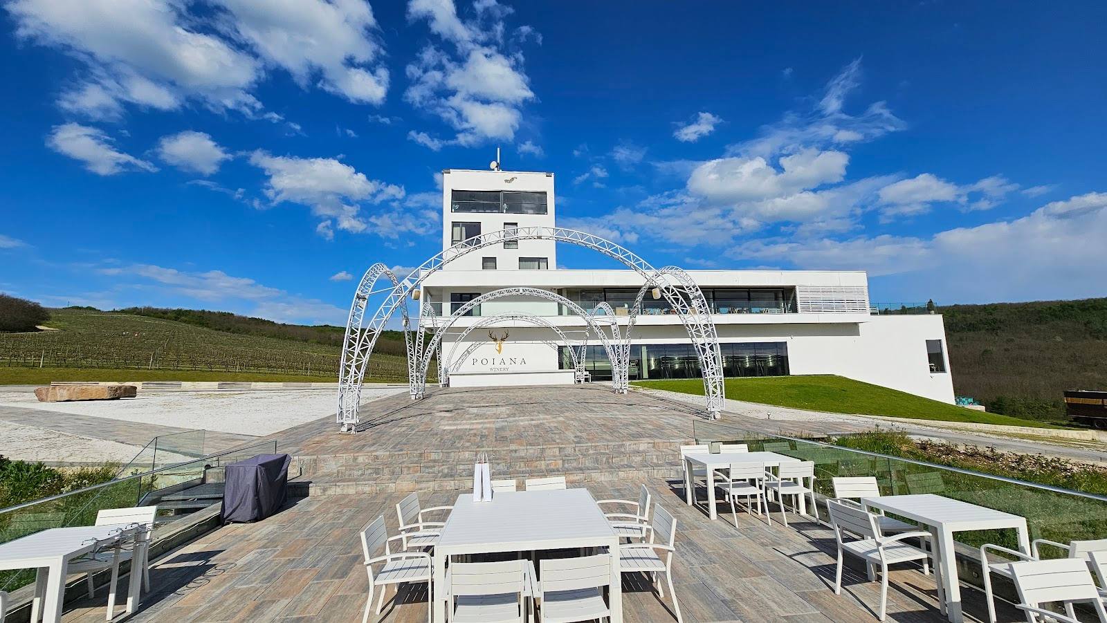 Modern architectural terrace with white seating overlooking rolling vineyard hills