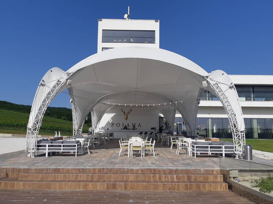 Modern white event tent with seating on elevated terrace, contemporary venue architecture