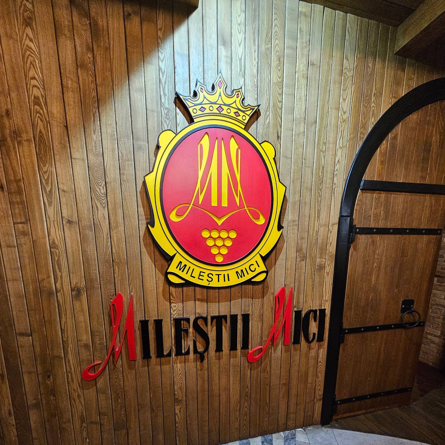 Wine cellar entrance sign with traditional heraldic emblem and wooden door