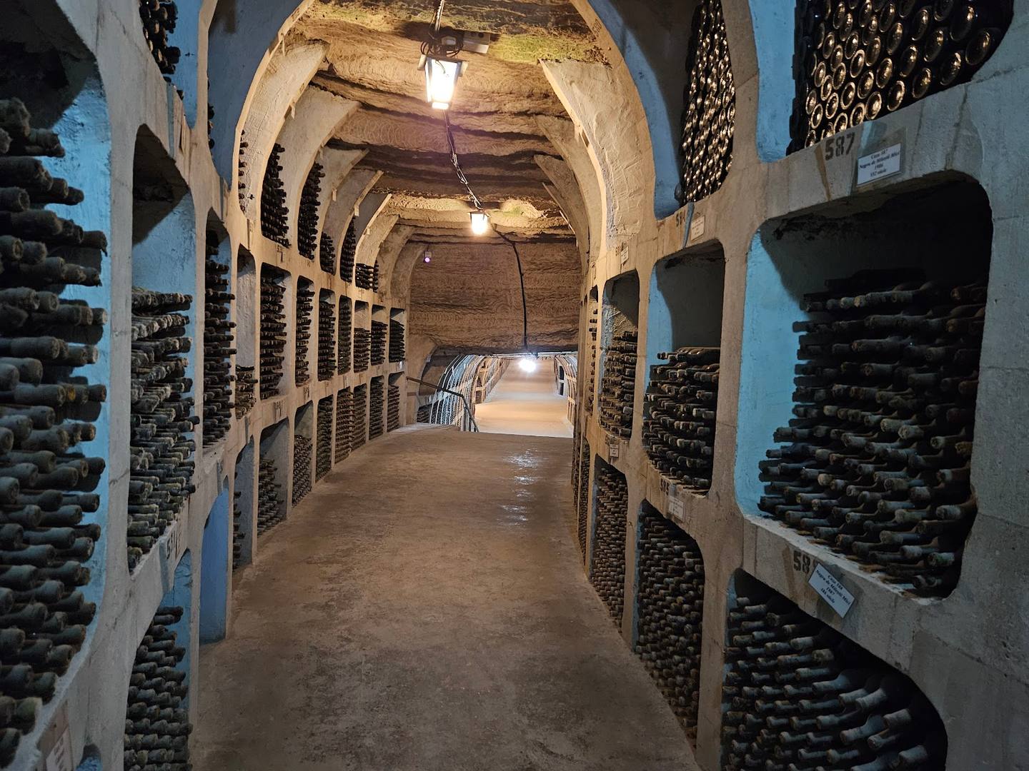 Wine cellar with barrel stacks and arched stone vault