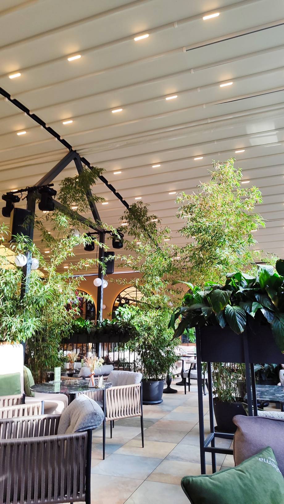 Modern event space with planted greenery, lounge seating, and ambient track lighting