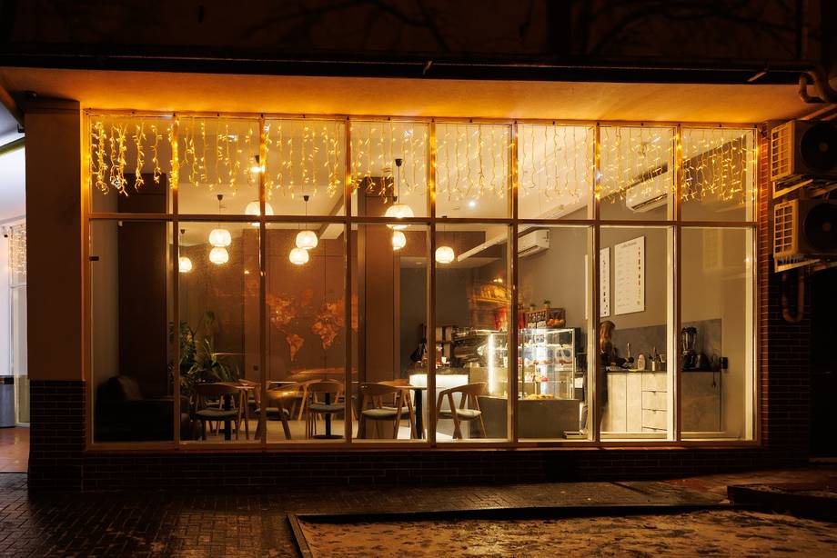 Storefront exterior at night with warm interior lighting and large display windows