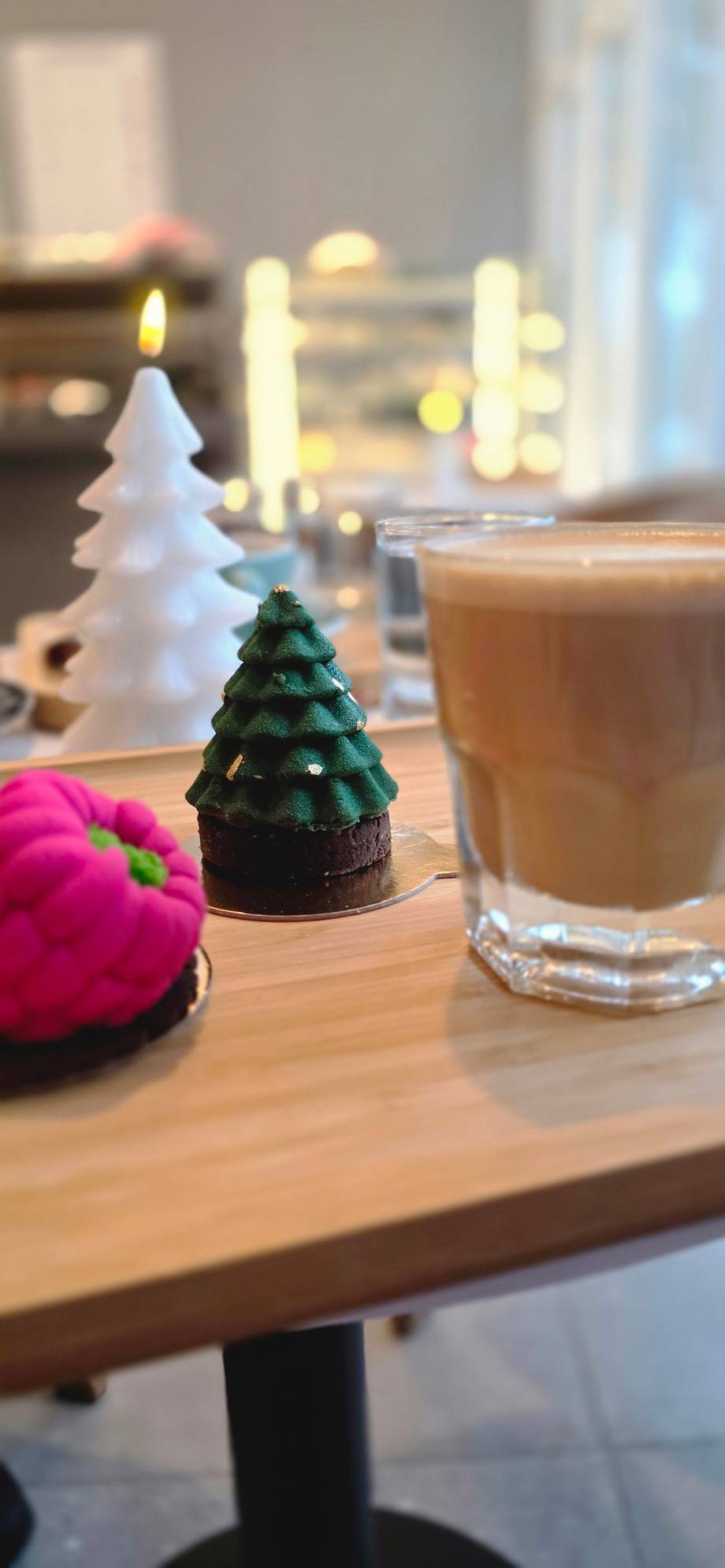 Holiday table detail with festive miniature trees, coffee drink, and seasonal decorations