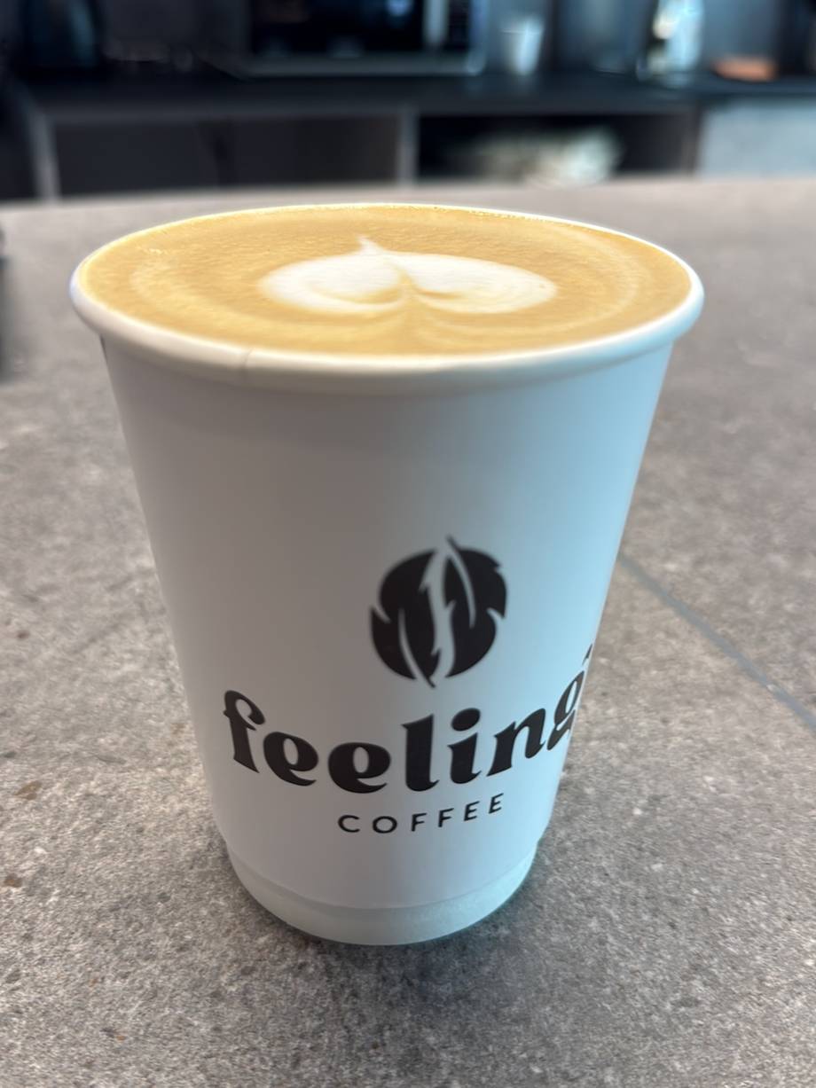 Latte with latte art in Feeling Coffee branded cup