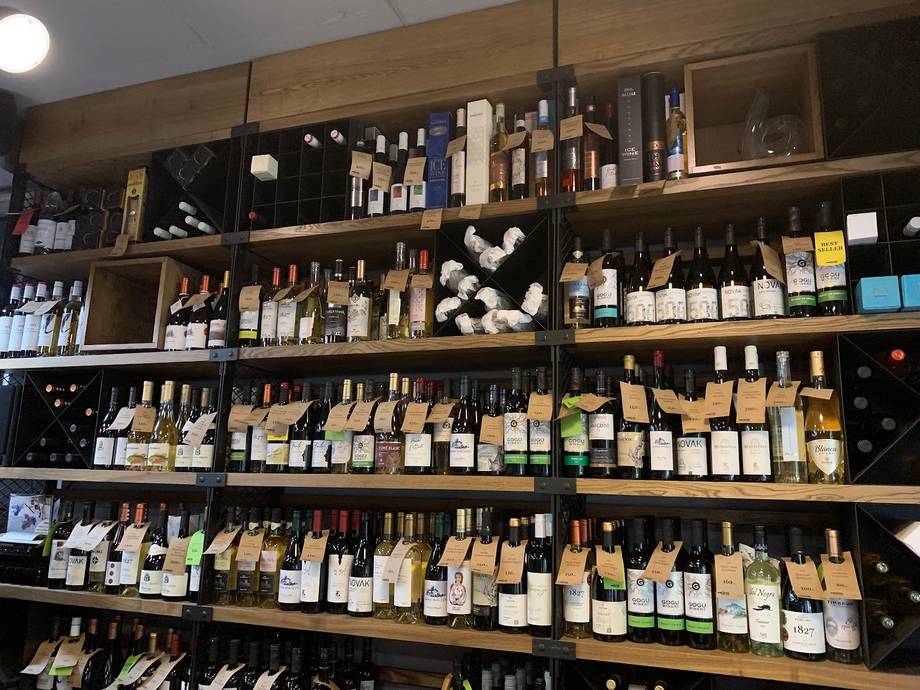 Wine shop back-bar wall displaying extensive collection of bottles and wine products across multiple shelves