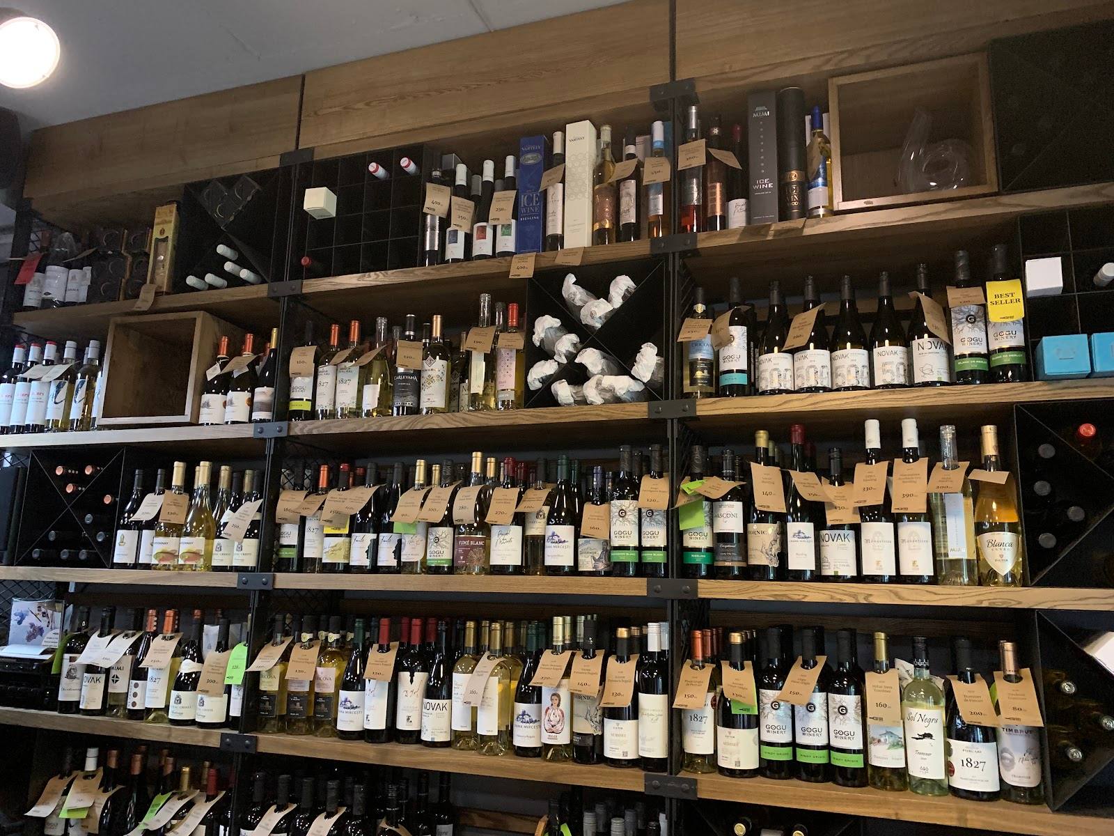 Wine shop back-bar wall displaying extensive collection of bottles and wine products across multiple shelves