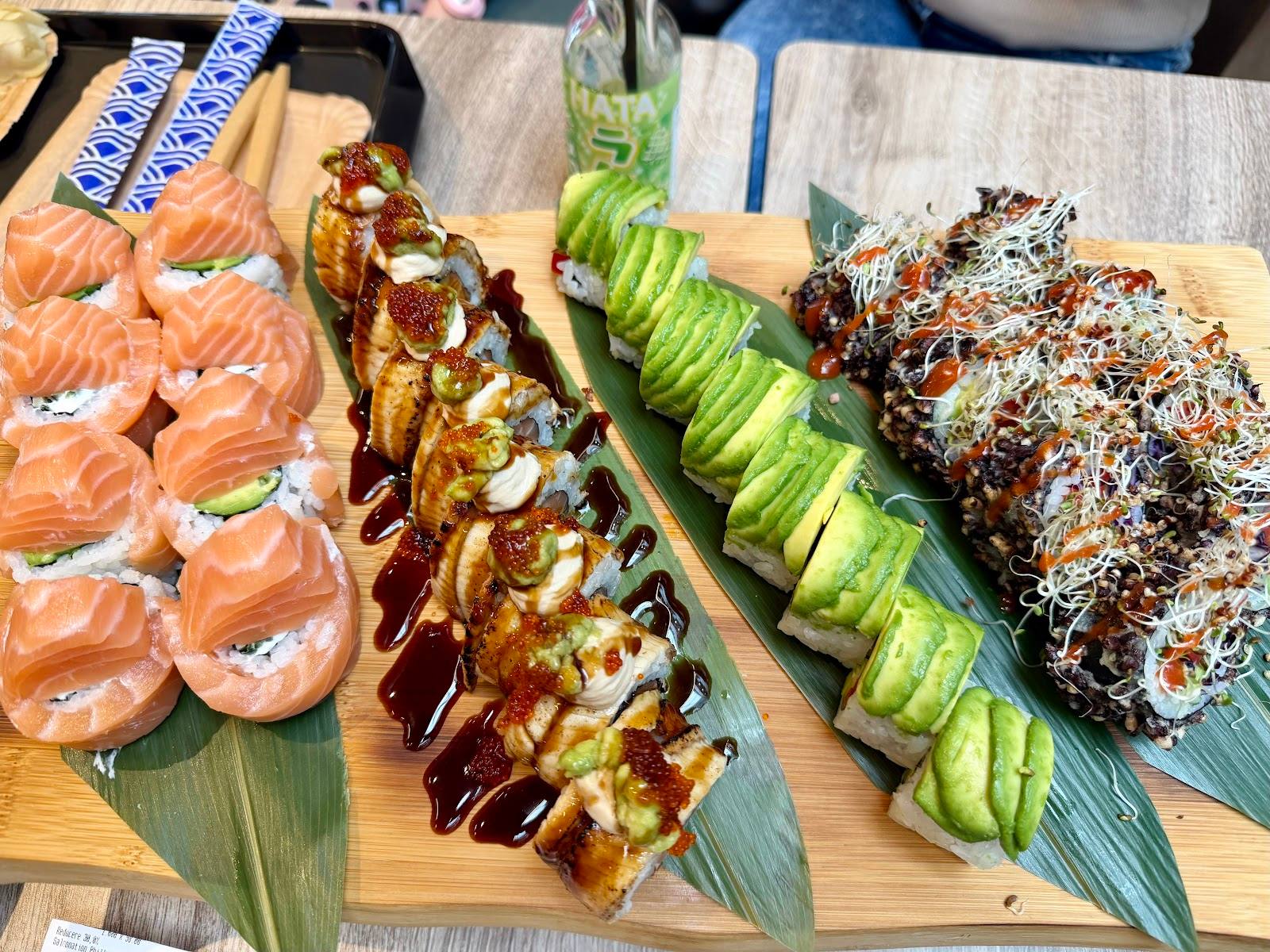 Assorted sushi rolls and appetizers arranged on wooden boards with garnish