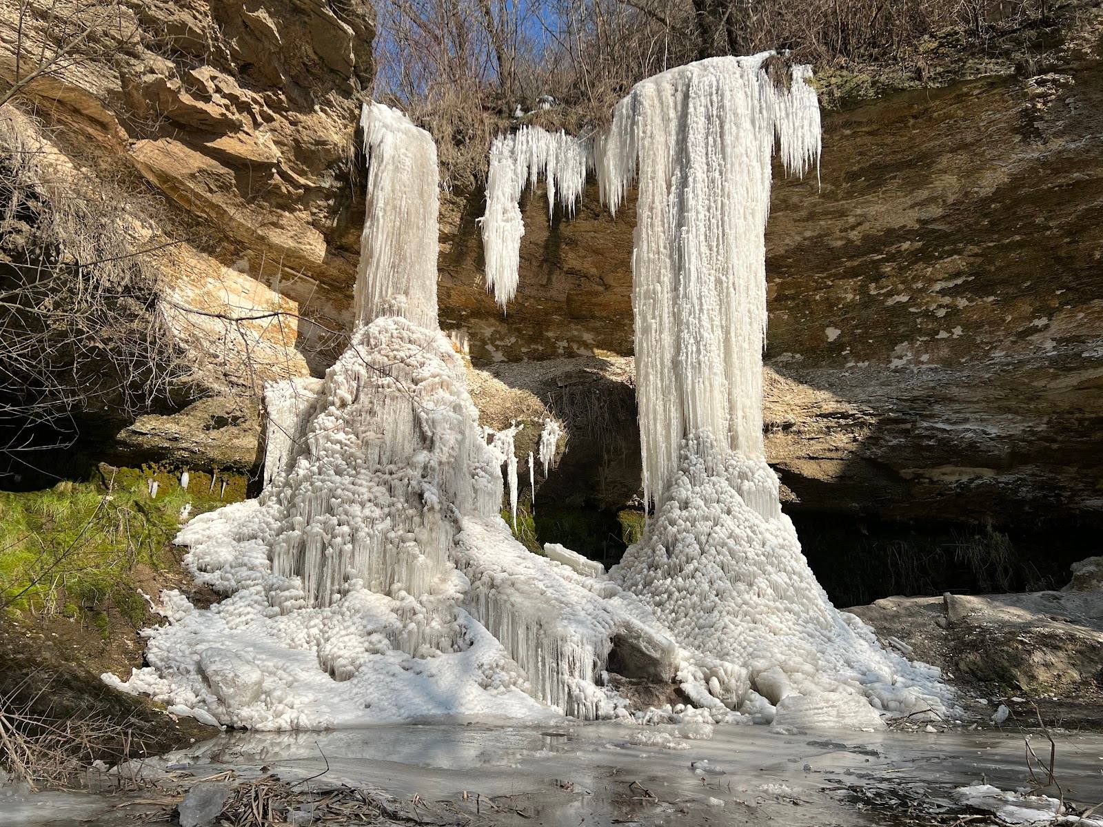 Frozen waterfall cascade with icicle formations at natural ravine landmark