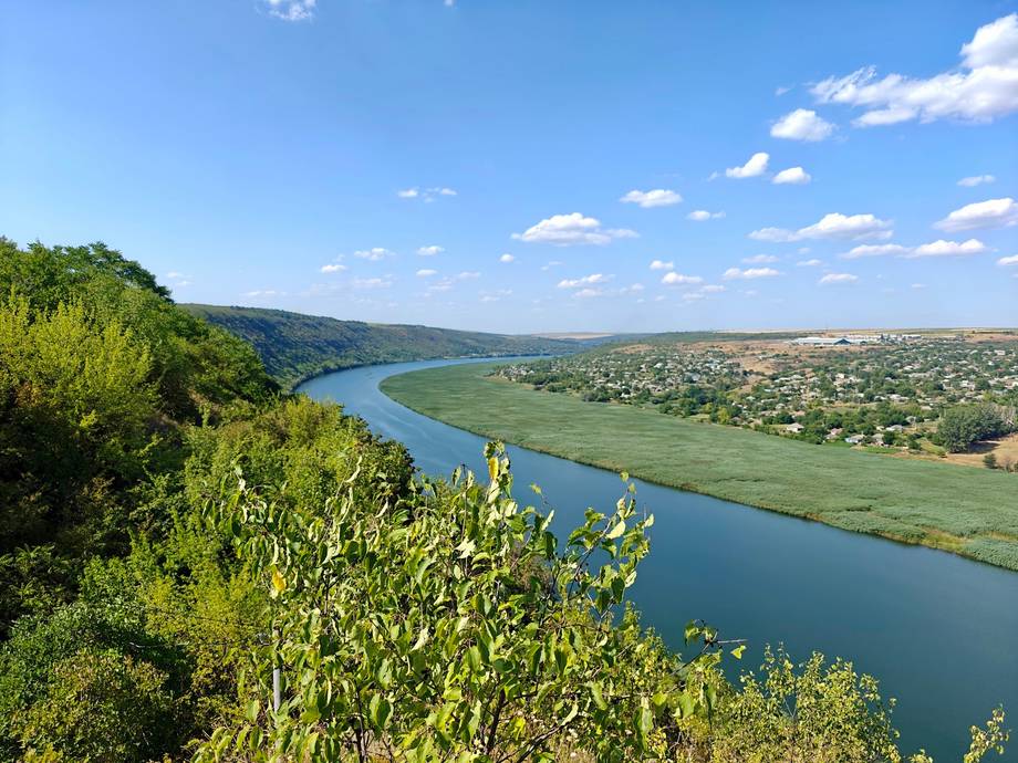 Panoramic river valley landscape with verdant rolling hills and clear sky