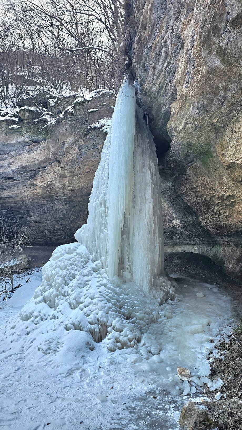 Frozen waterfall cascade between rocky cliffs in winter landscape