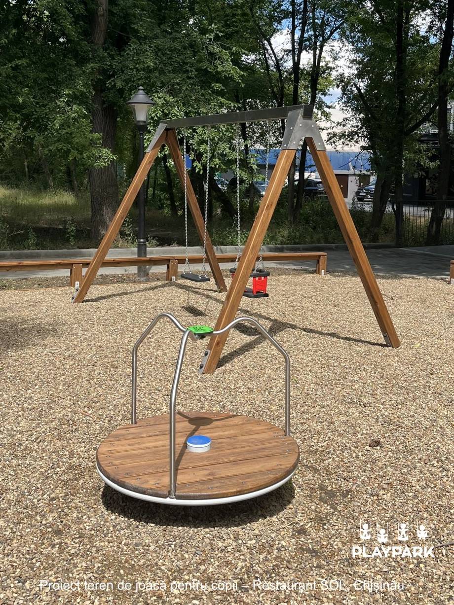 Modern wooden playground equipment with swing and spinning structure in outdoor park setting