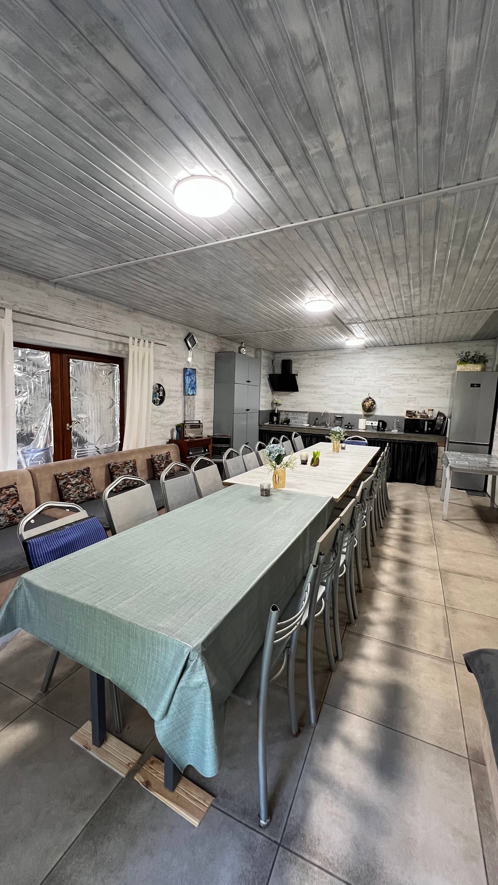 Open-plan dining and kitchen space with striped metal ceiling and bright natural light