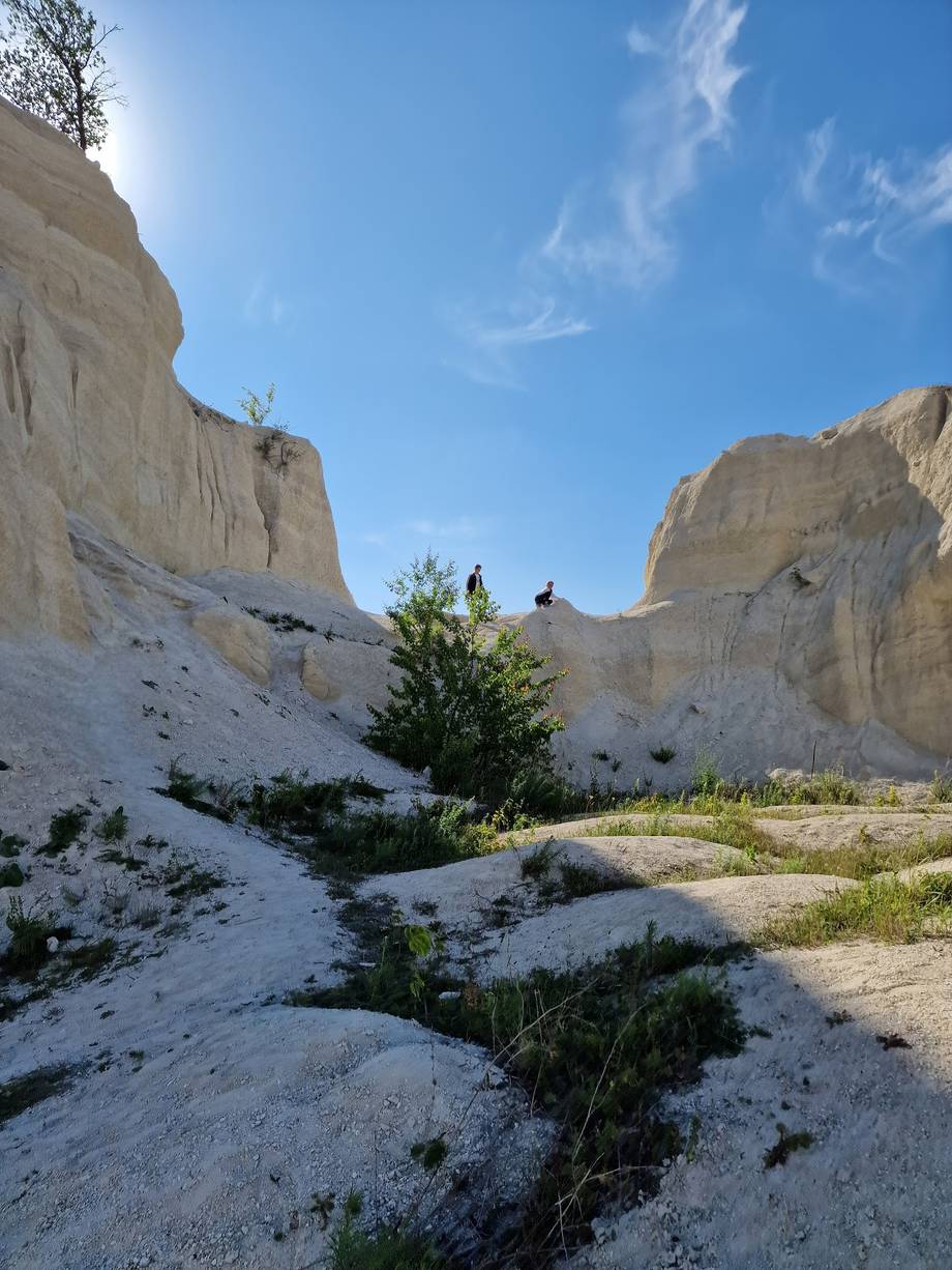Natural limestone canyon landscape with towering white cliffs and sparse vegetation