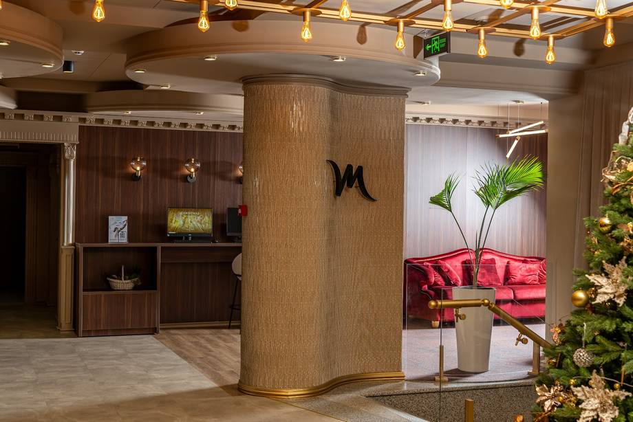 Modern hotel or spa lobby with warm wood finishes, reception desk, and contemporary seating lounge