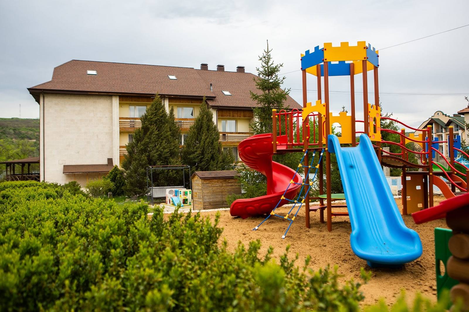 Family venue exterior with children's playground and red brick house