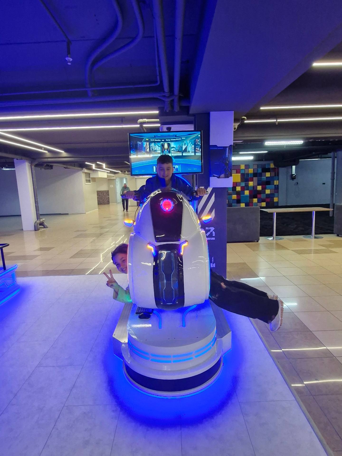 VR racing simulator with blue neon lighting in modern entertainment venue