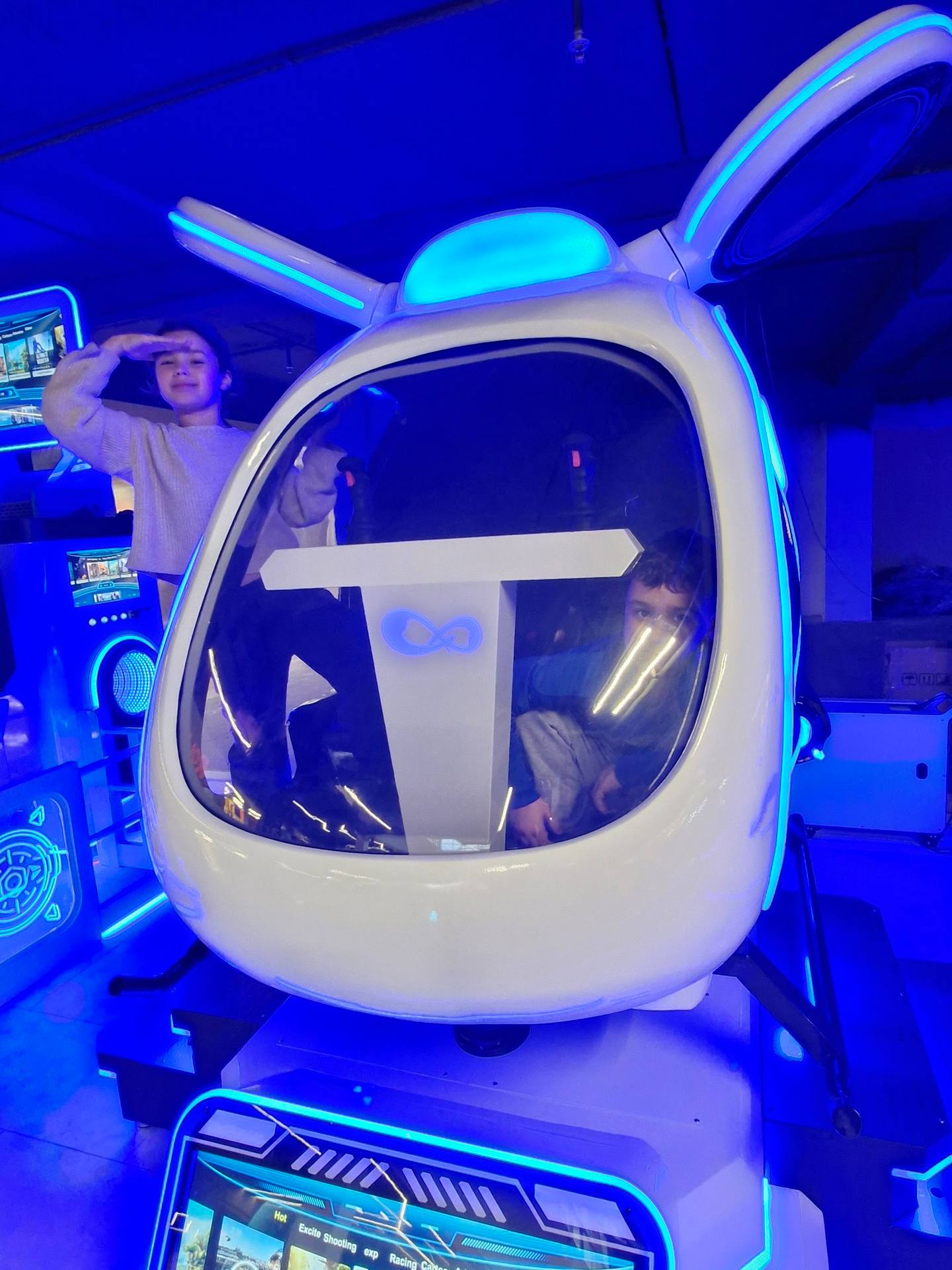VR gaming simulator pod with neon blue lighting in entertainment venue
