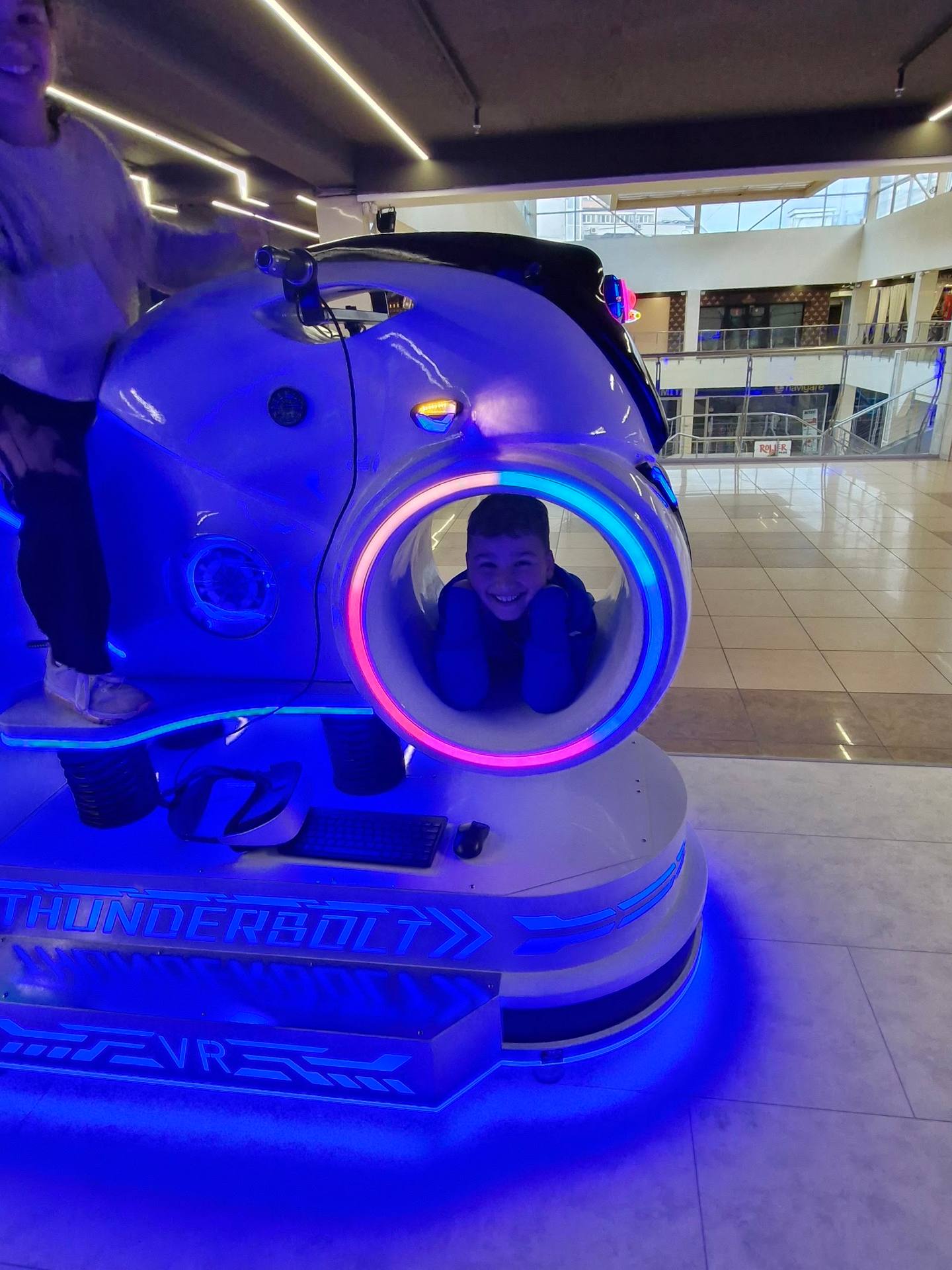 VR motion simulator with neon blue lighting in an entertainment venue