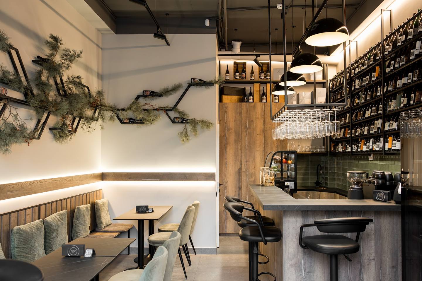Modern cafe interior with seating area, bar counter, and plant wall decor