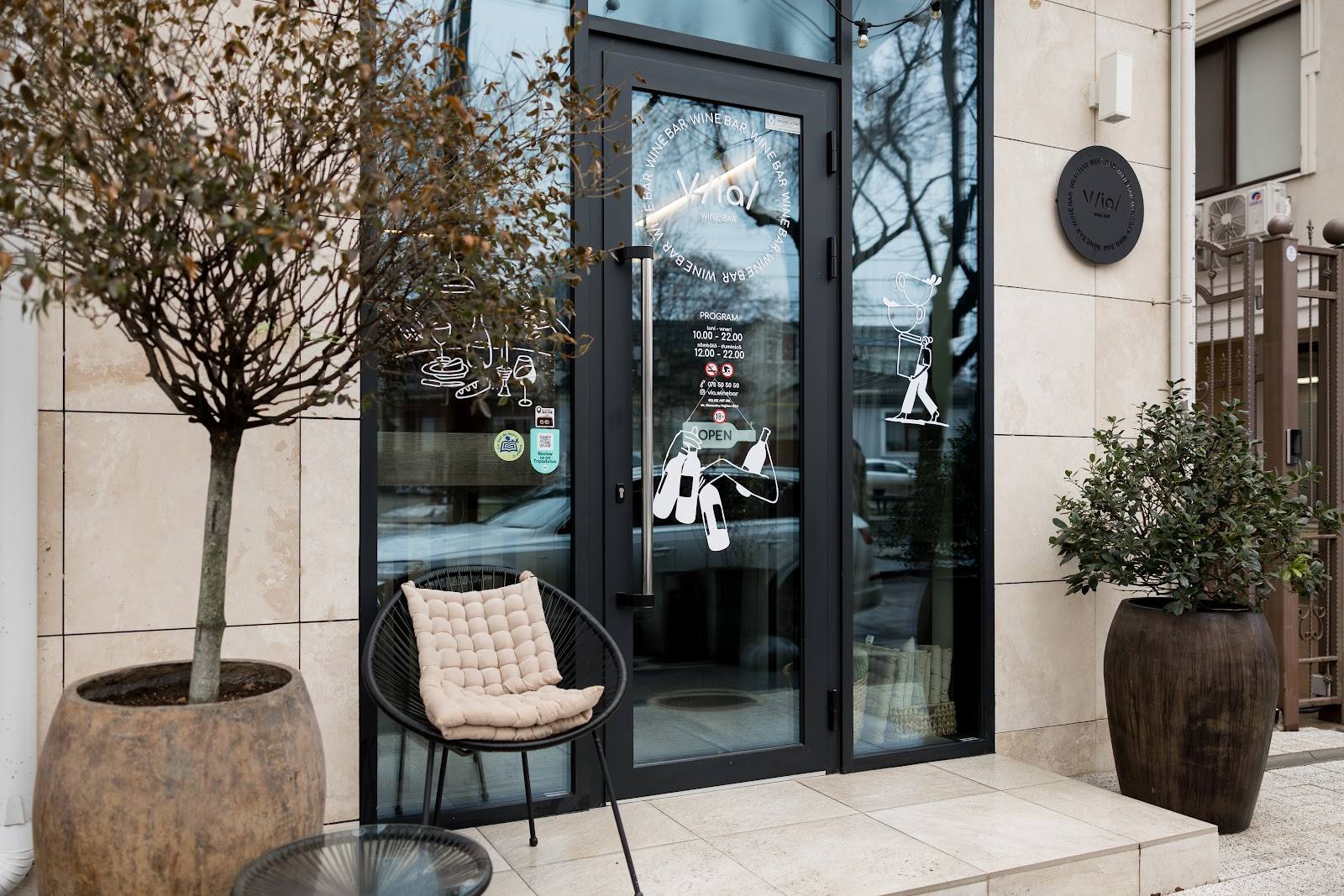 Modern storefront with black glass doors, minimalist seating, and contemporary facade design