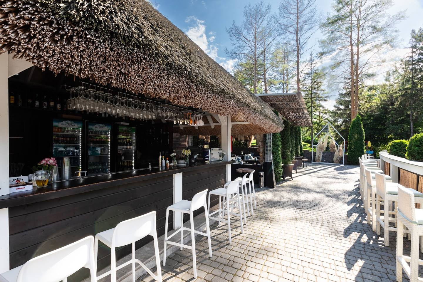 Thatched-roof cafe with terrace seating and woodland setting