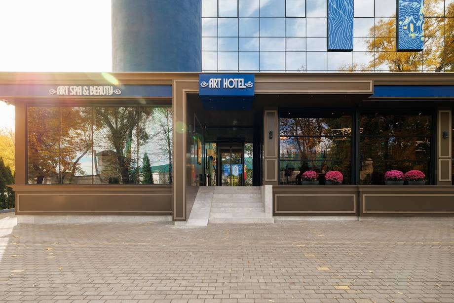 Art Hotel storefront with signage, large windows, and decorative planters at street level