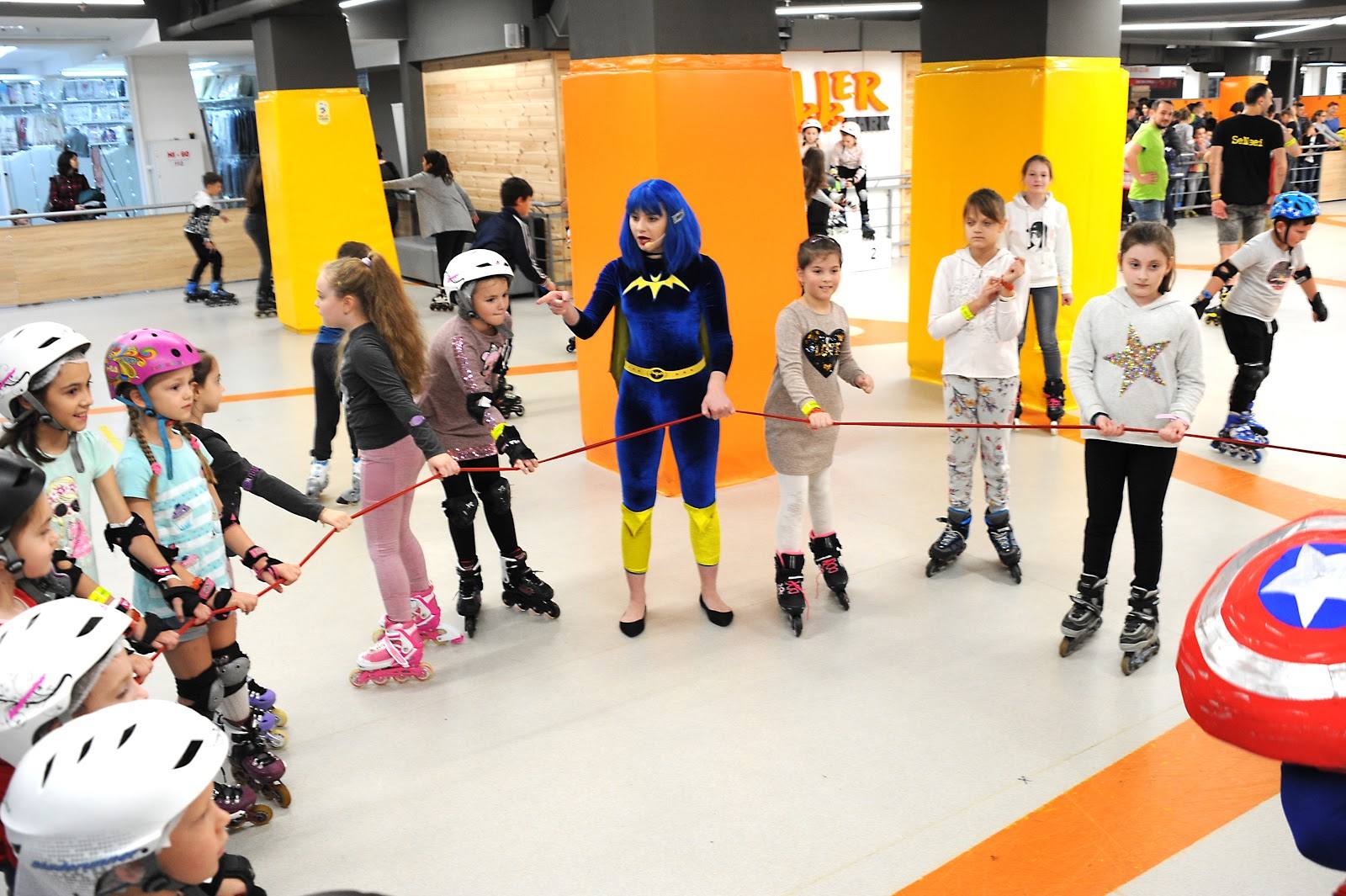 Group of children roller-skating in a bright indoor sports venue with colorful walls and Marvel character decor