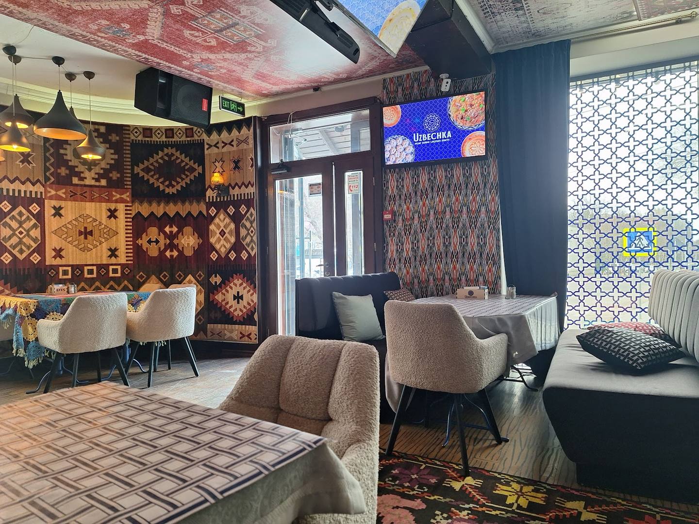 Modern cafe interior with geometric patterned wall, contemporary seating, and ambient lighting