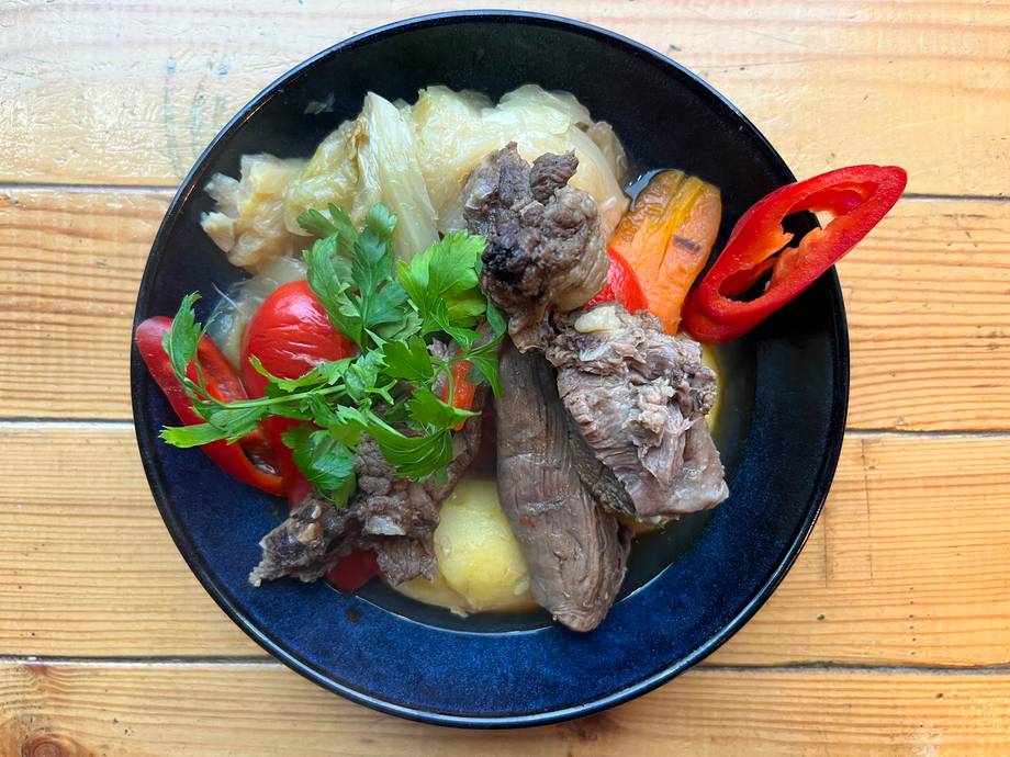 Plated beef steak with vegetables and garnish on dark blue dish