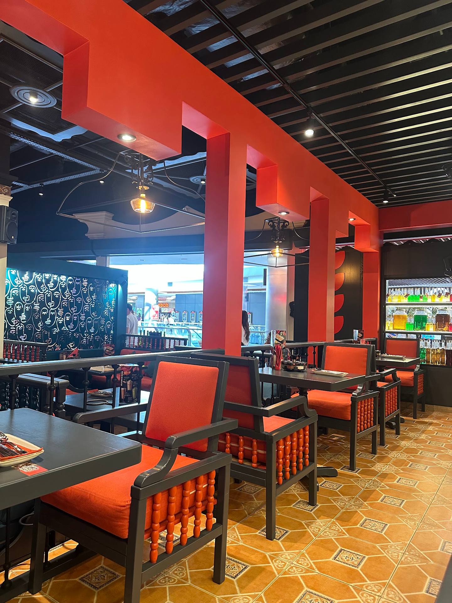 Modern restaurant interior with bold red structural columns and contemporary seating