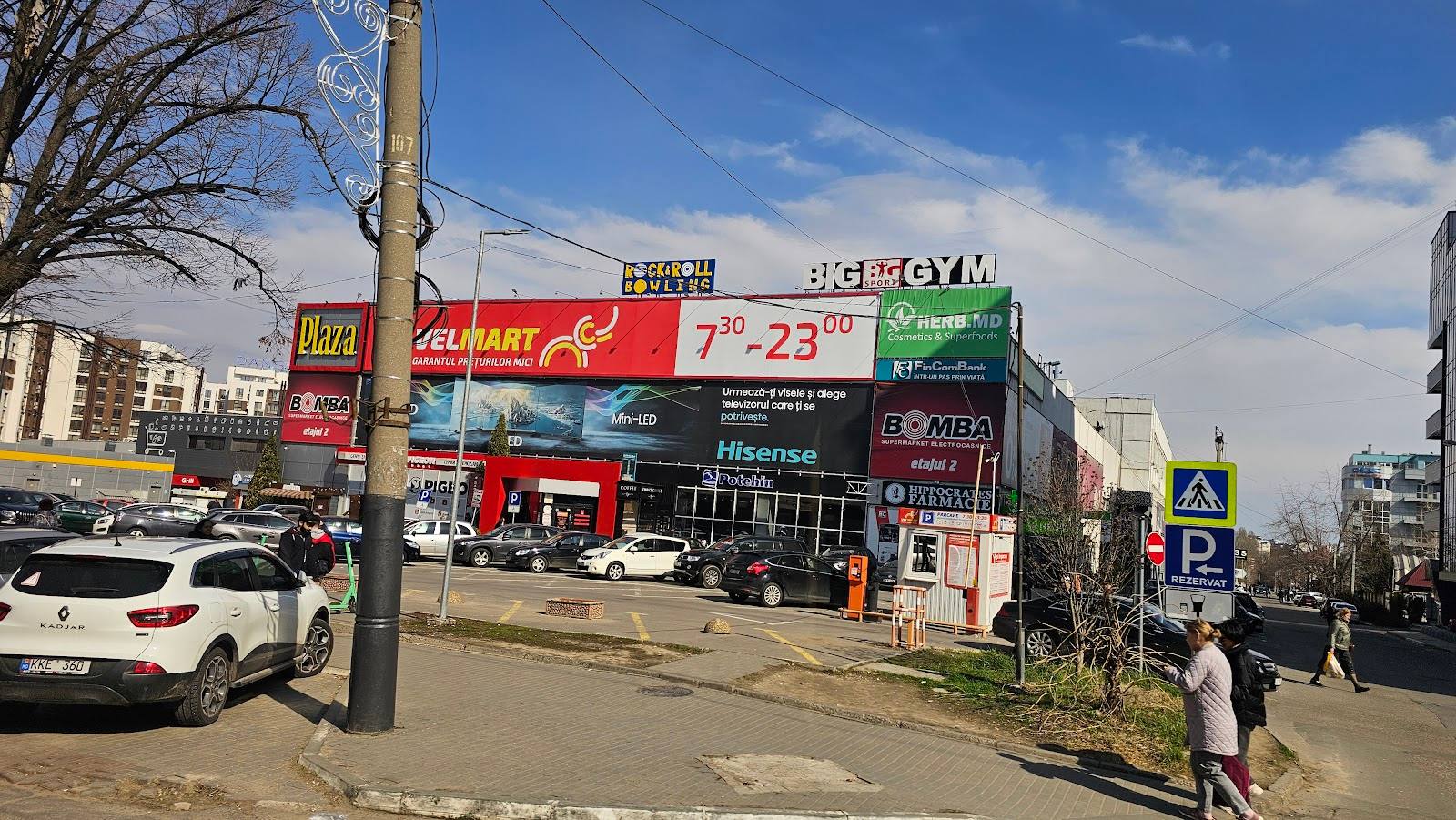 Commercial shopping center exterior with multiple retail storefronts and signage