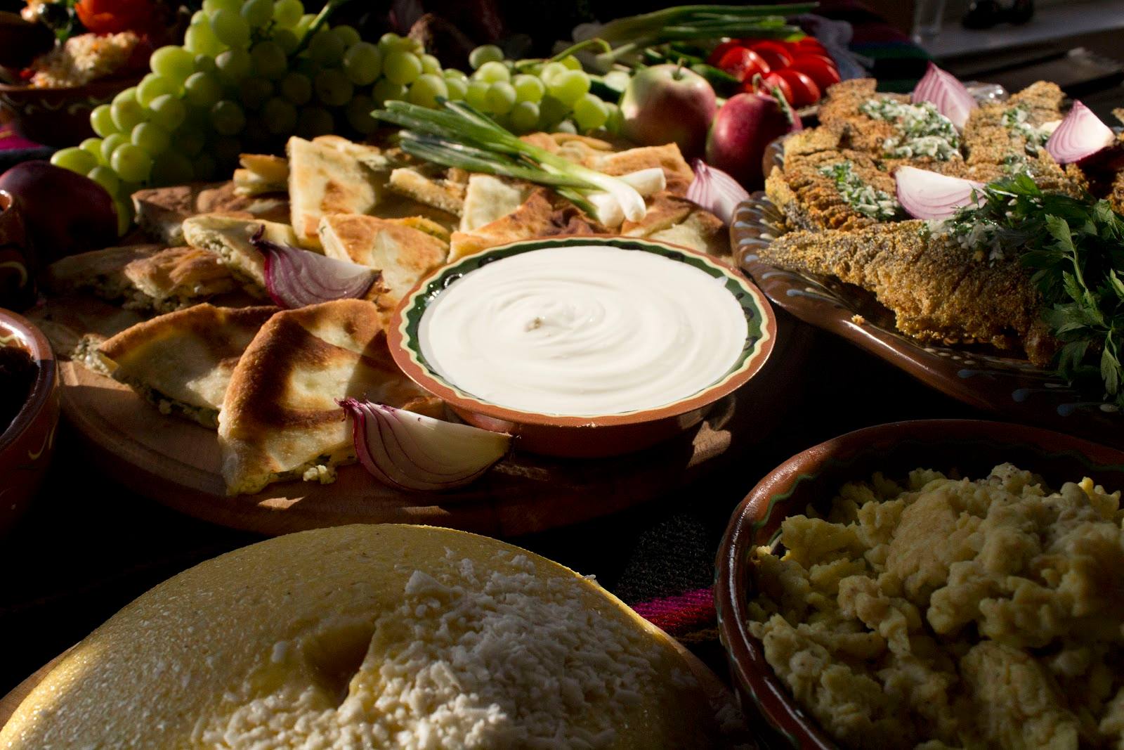 Spread of traditional Eastern European dishes with fresh vegetables and cream sauce