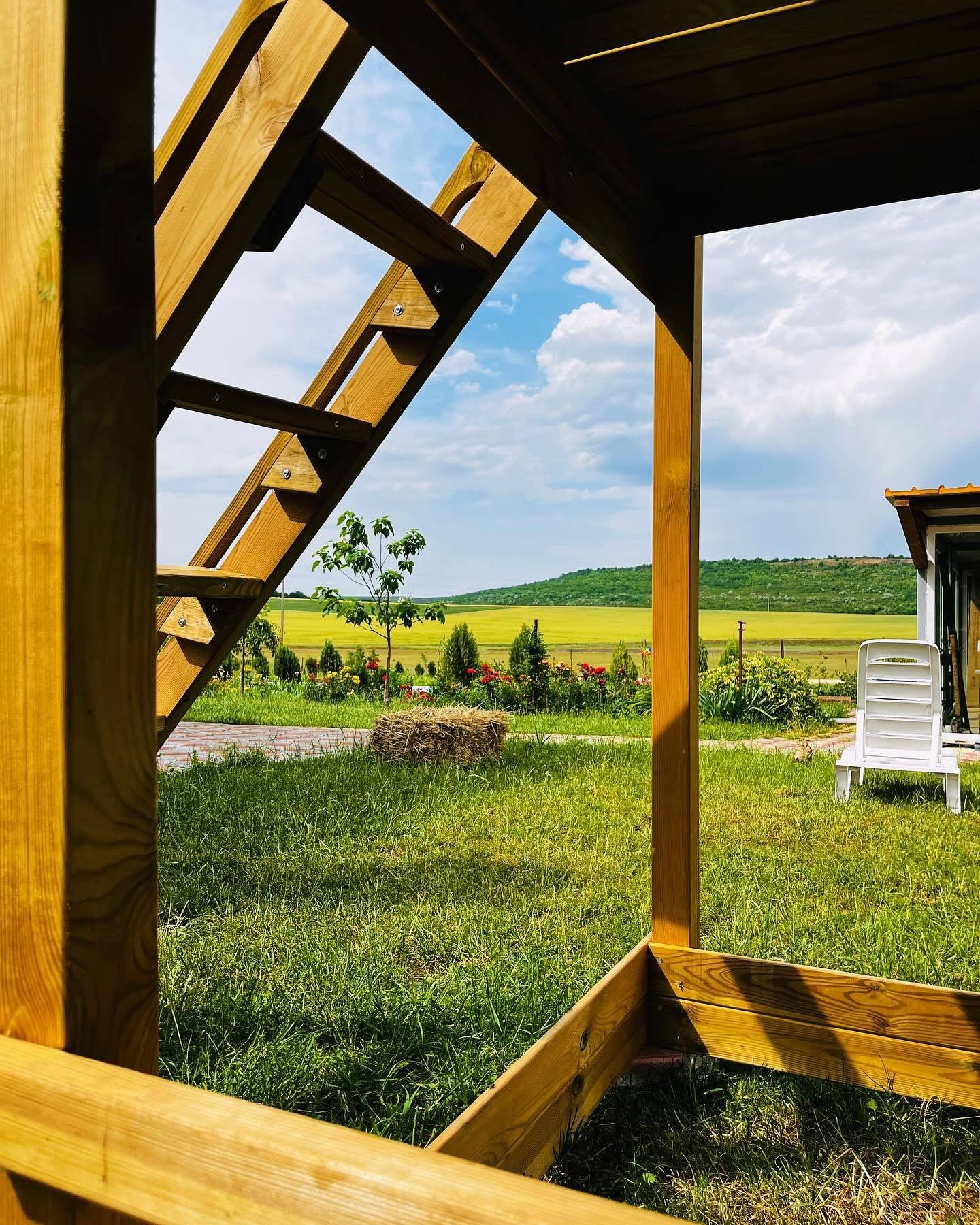 Wooden pergola terrace framing vineyards and rolling green fields in Moldova