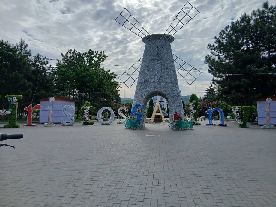 Iconic windmill landmark with colorful installation and paved plaza