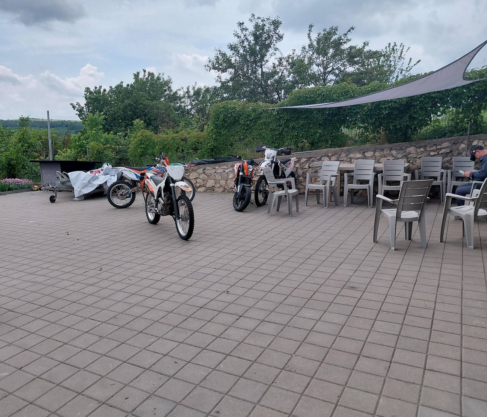 Outdoor terrace with vintage motorcycles and seating area under covered awning