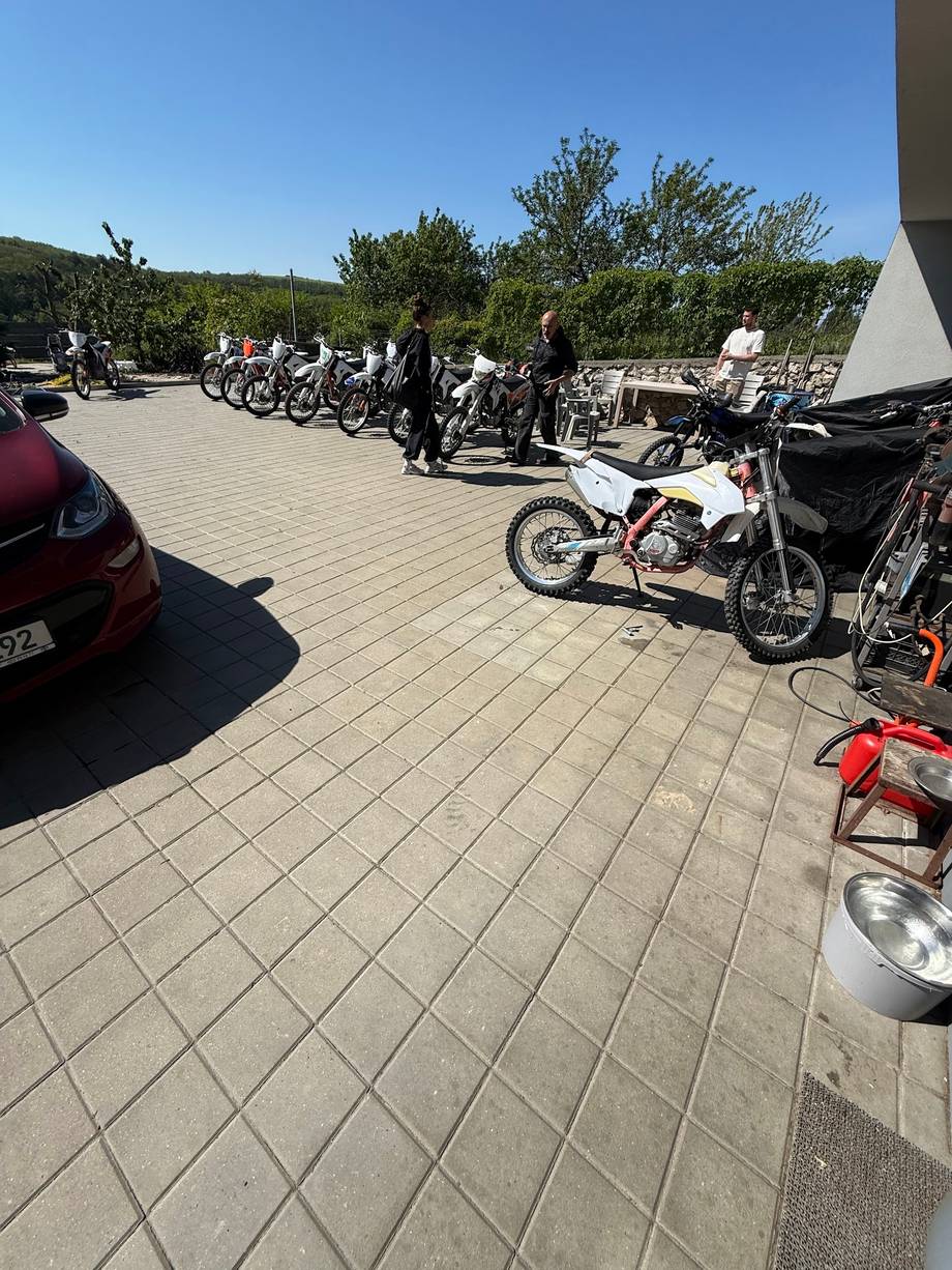 Motorcycle and motorbike gathering in paved outdoor parking area with natural landscape backdrop